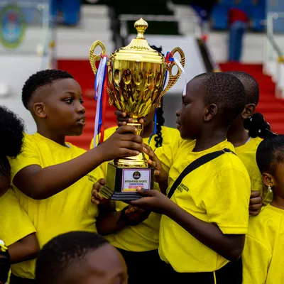 Pupils lifting the champions' trophy